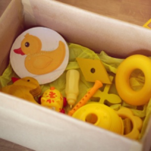 Na imagem: Caixa com diversos objetos amarelos.
